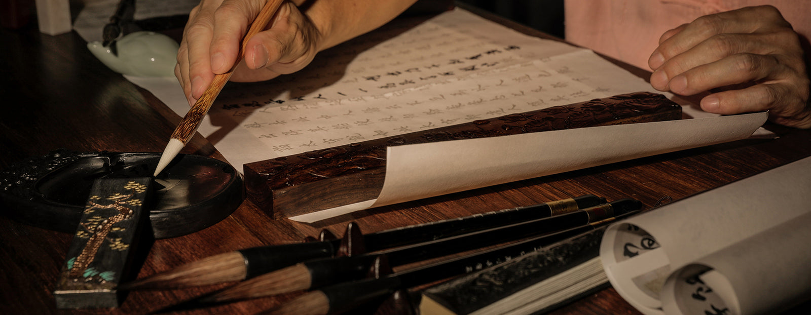 Chinese Calligraphy Artist practicing writing Chinese characters with a Chinese Brush and using the 4 Treasures of the Study