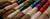 Assortment of Chinese Collectors and Home Decor Calligraphy and Sumi Brushes with colorful handles in red, blue, green and violet.