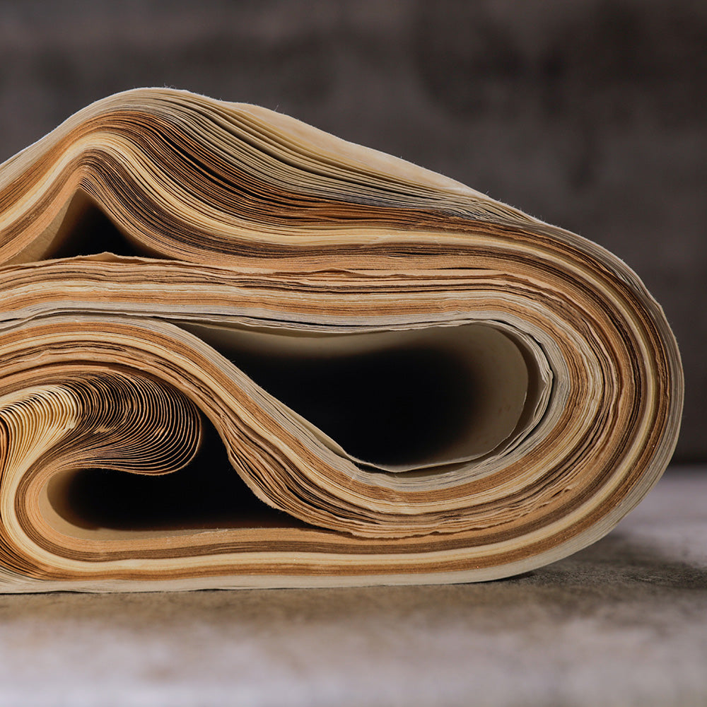 Chinese Shuen Paper for Calligraphy and Sumi rolled-up and closeup view from the side showing different shades of beige and brown