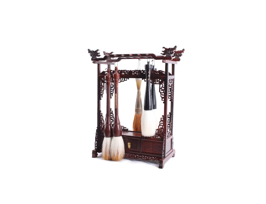Brushes hanging on a two-sided Chinese brush hanger for calligraphy and sumi brushes displaying the usage of this wooden rack with hand carved dragon heads and drawer for signature seal.