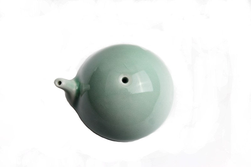 Detail invidual view of traditional Chinese brush painting water dropper made of white ceramic and shaped like a tea pot