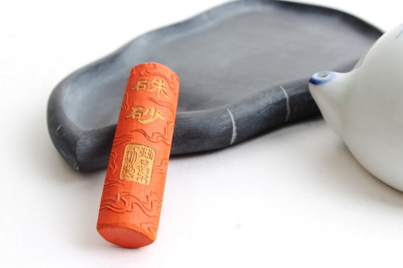 Japanese Calligraphy and Sumi Ink Stick in red color with cinnabar pigment, decorated with manufacturer&#39;s name in golden lettering and a crouching dragon on the other side