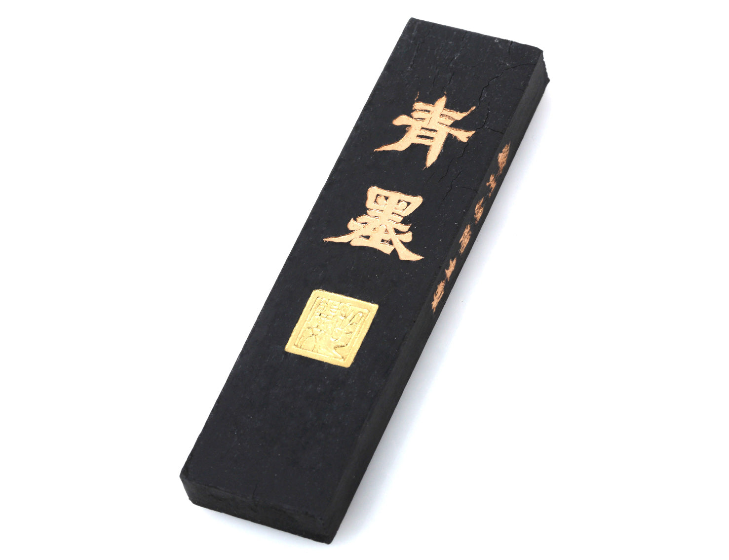 Traditional Chinese / Japanese ink stick for sumi painting and calligraphy writing with golden characters decorating its body; producing ink in a shade of dark-blueish green