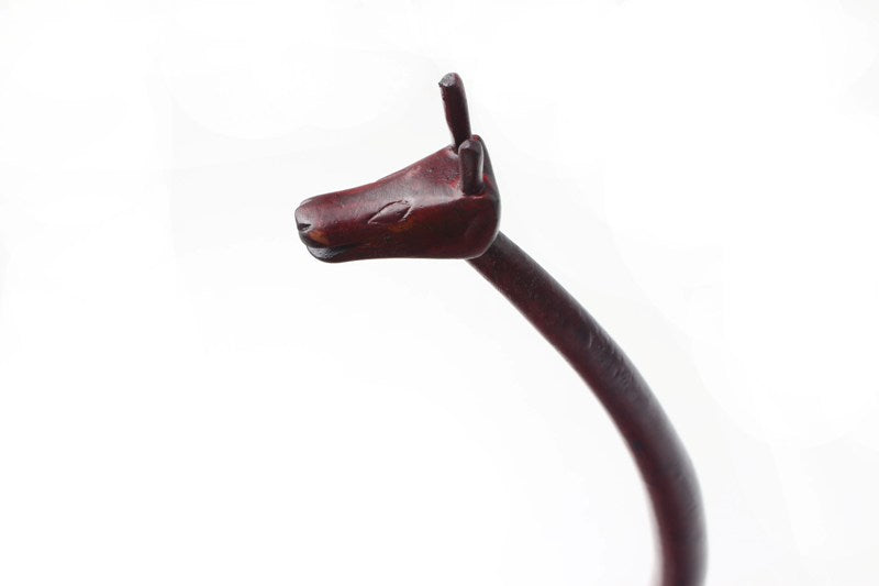 detail view of the head of the giraffe with the   two hangers pointing out to hang up brushes