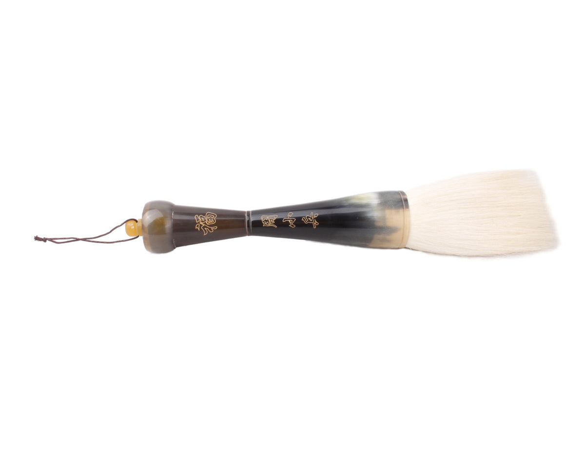 front view of the happiness highland goat hair brush lying horizontally with a nice artsy touch