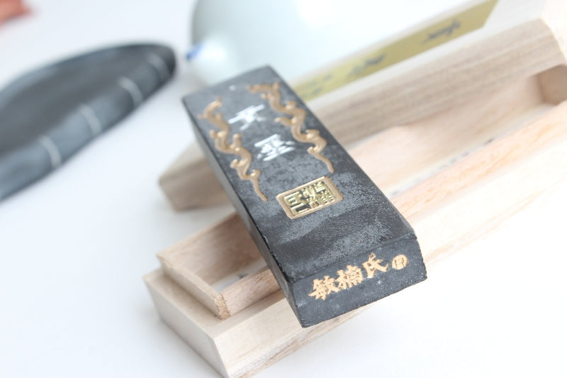Golden Chinese characters on the back of a Chinese mid-range ink stick