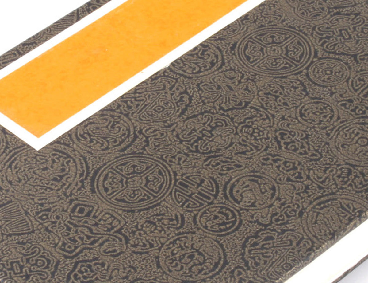 detail view of the cover of Accordion Fold Brush Painting Album | Bronze Cover where the relief characters on the cover is clearly seen