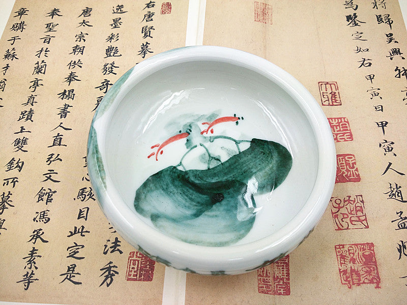 Top view of Oriental brush washer displaying the Twining Fish hand painted on the bottom and made of white Chinese ceramic used for calligraphy and sumi painting.