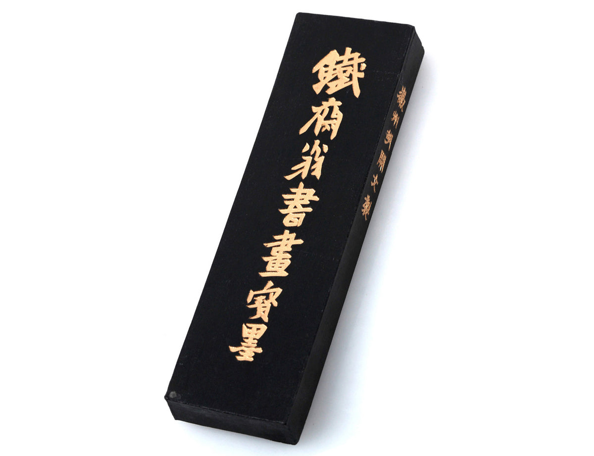 Classic black Chinese &amp; Japanese ink stick with golden plum tree branch and white flower decorations and golden Chinese characters on the back side.