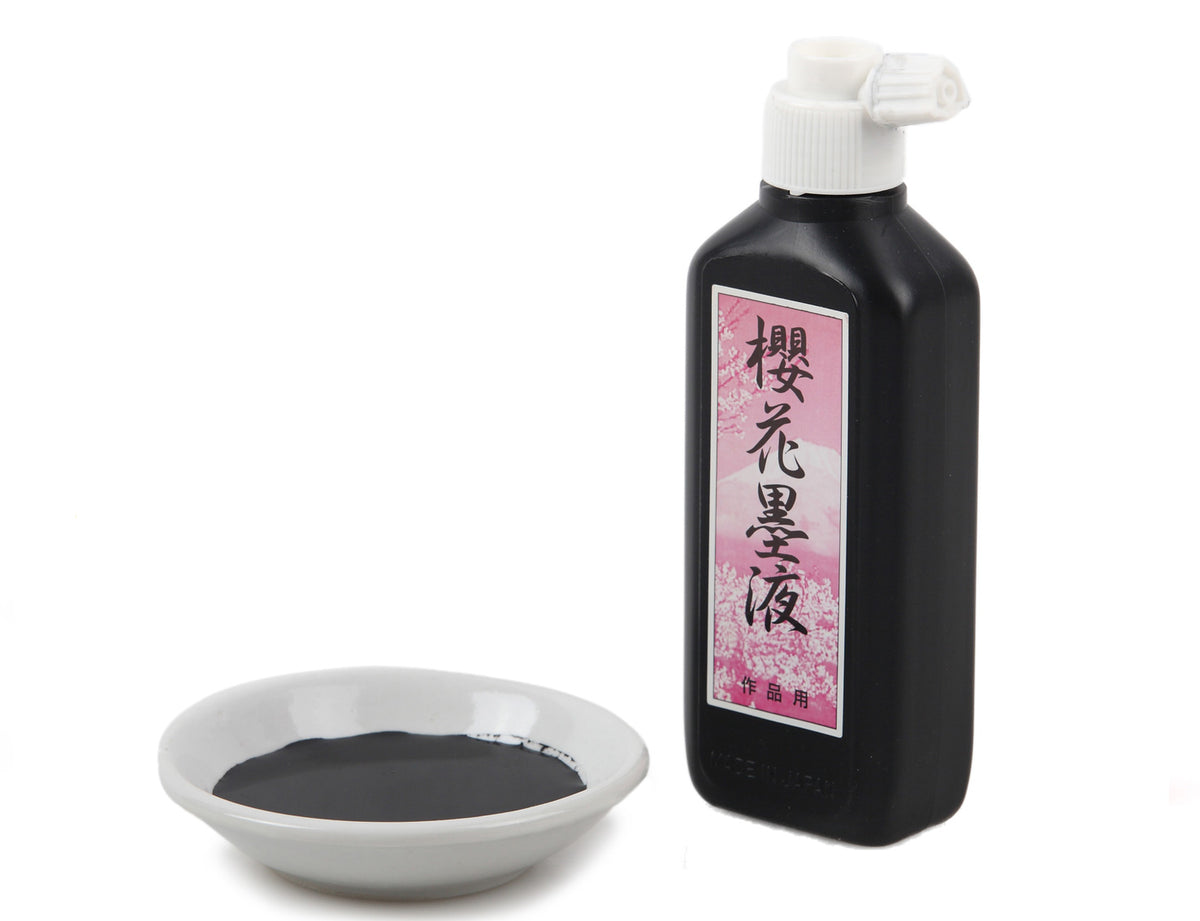 Traditional color mixing bowls for Oriental brush painting made of white ceramic and shaped like a saucer - containing black Chinese sumi ink