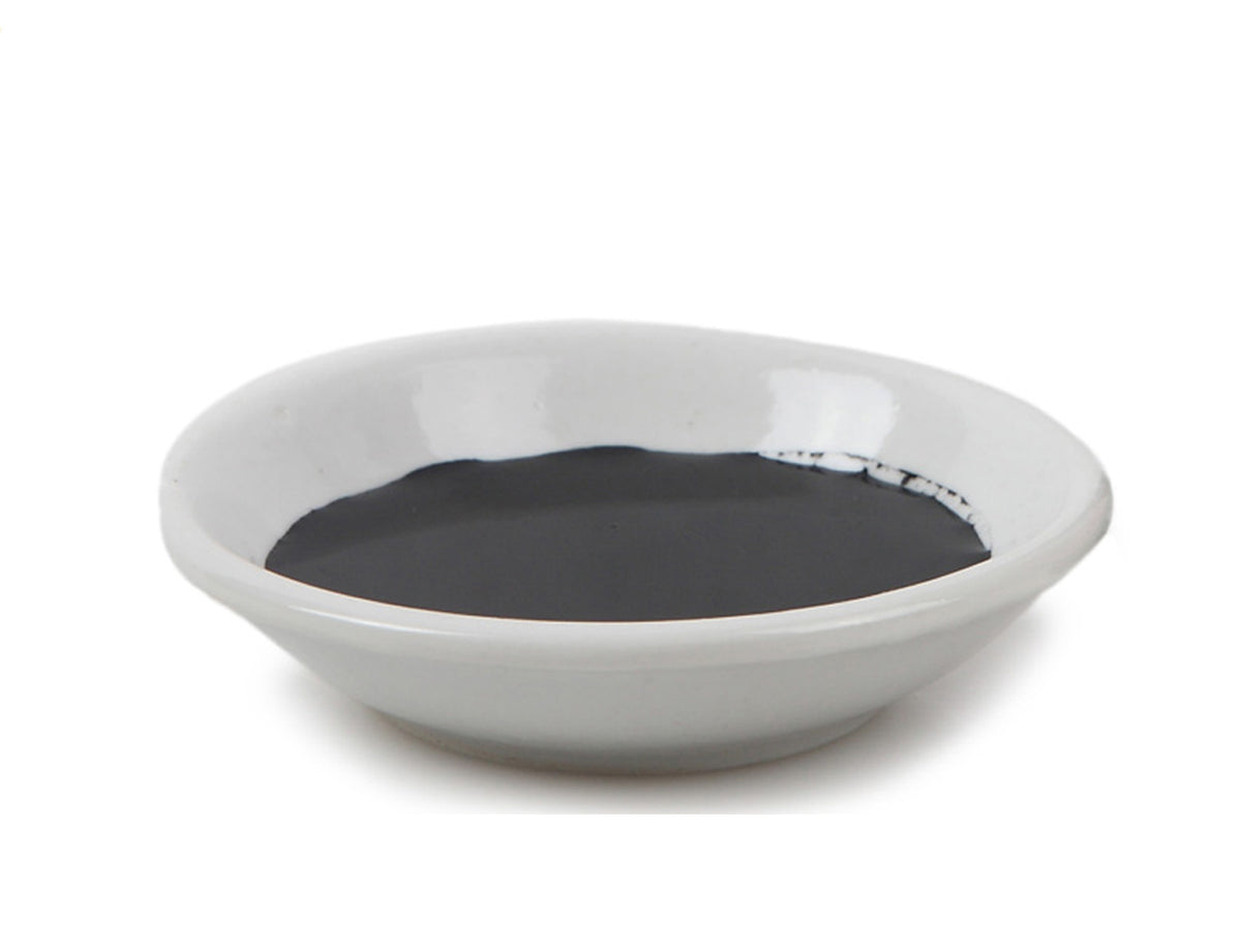 Display of traditional white Chinese ink container used to ready sumi and calligraphy ink for painting and writing together with bottle of Oriental sumi ink