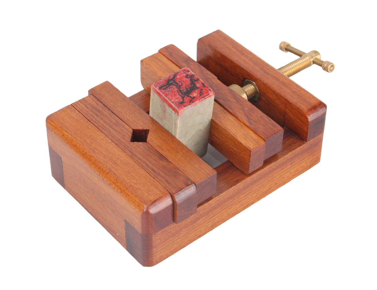 usage view of this seal carving stand with a chop put in between the wood chips which makes it stable for carving