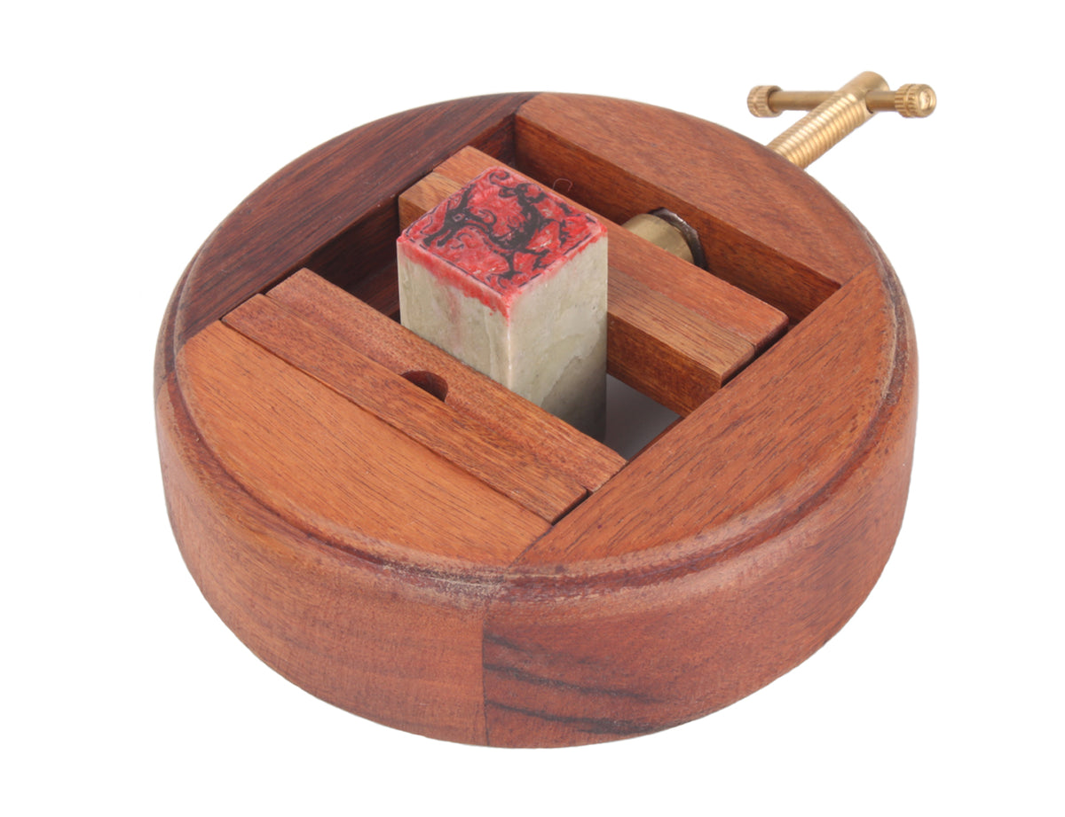 usage view of this seal carving stand with a chop put in between the wood chips which makes it stable for carving