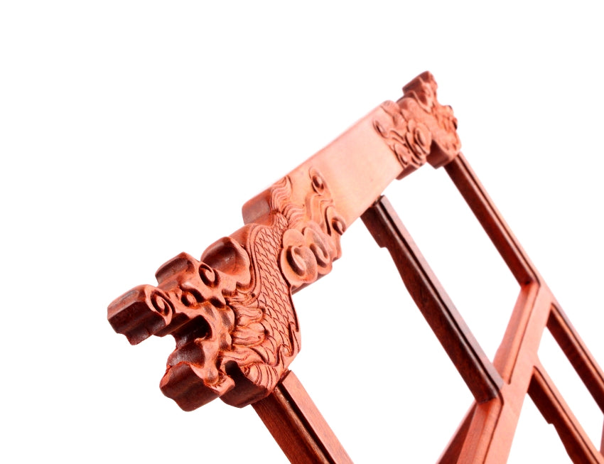 Close-up zoom view of the hand carvings of Chinese dragons decorating a wooden Oriental learning material stand that can be folded for better storage